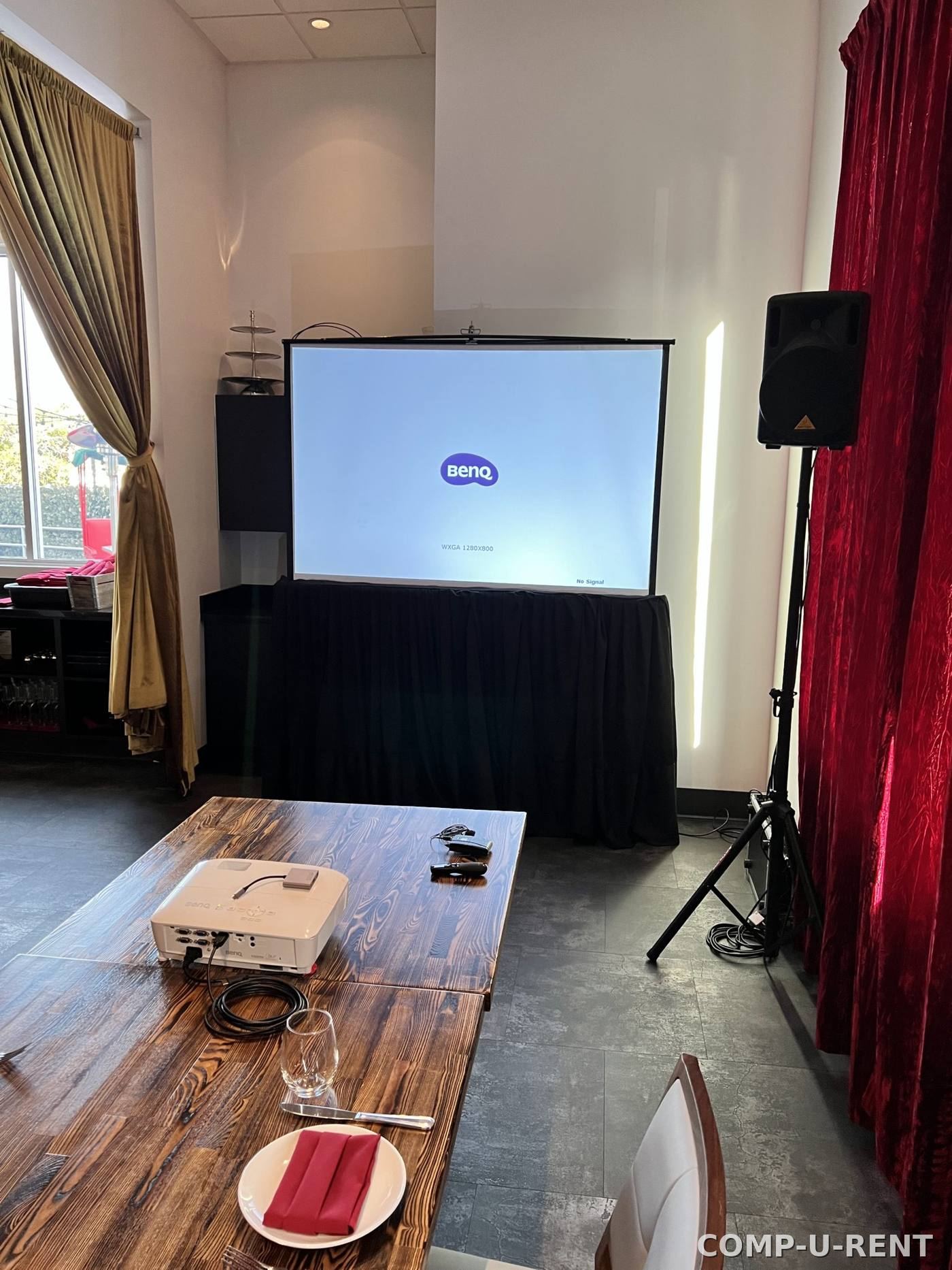 BenQ projector and pull-down screen set up for a private event